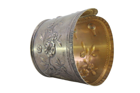 Argola de guardanapo em prata em forma de punho e relevada com motivos florais.